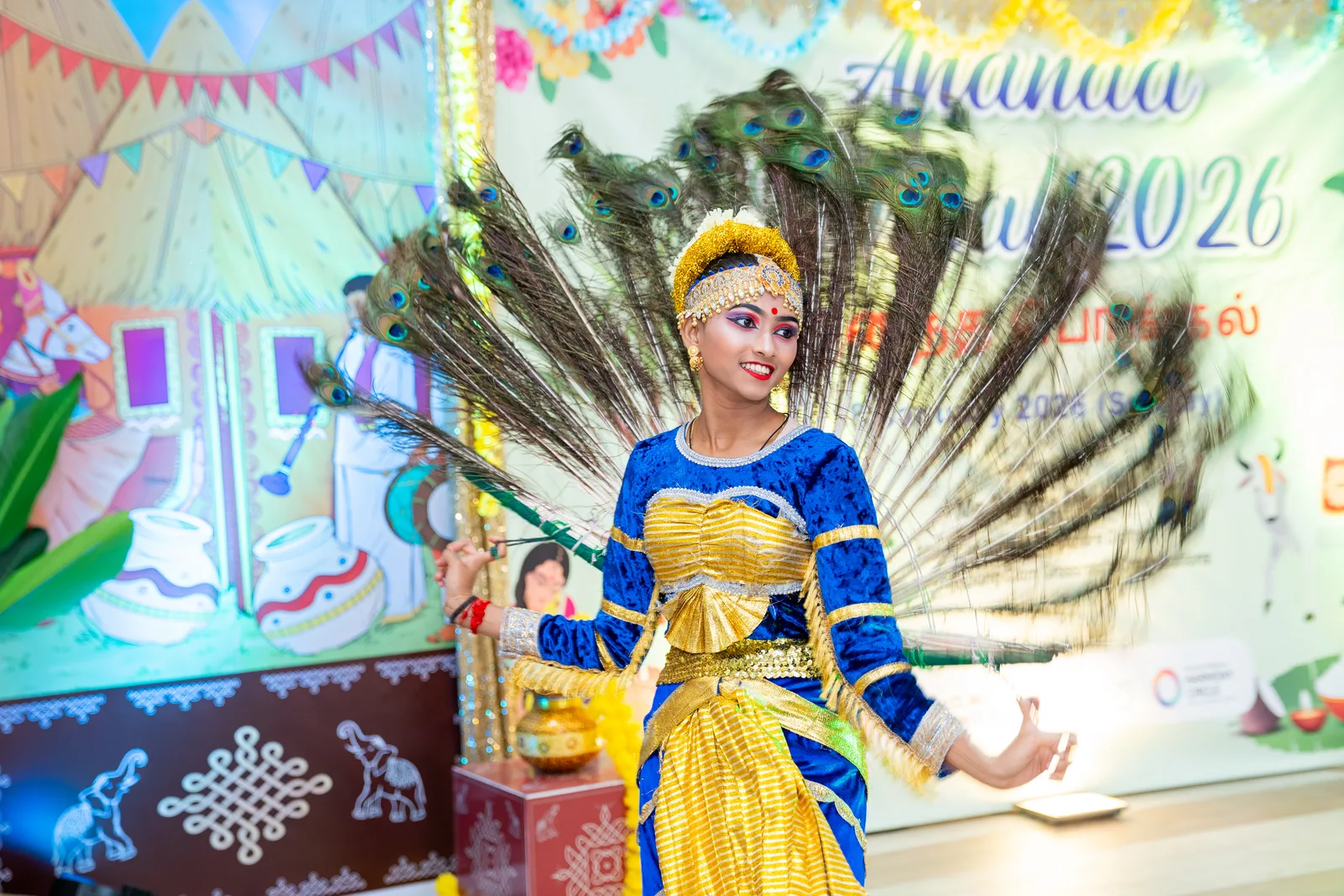 Peacock-costume dancer against a vibrant festival backdrop — sharp subject, saturated colour, confident composition