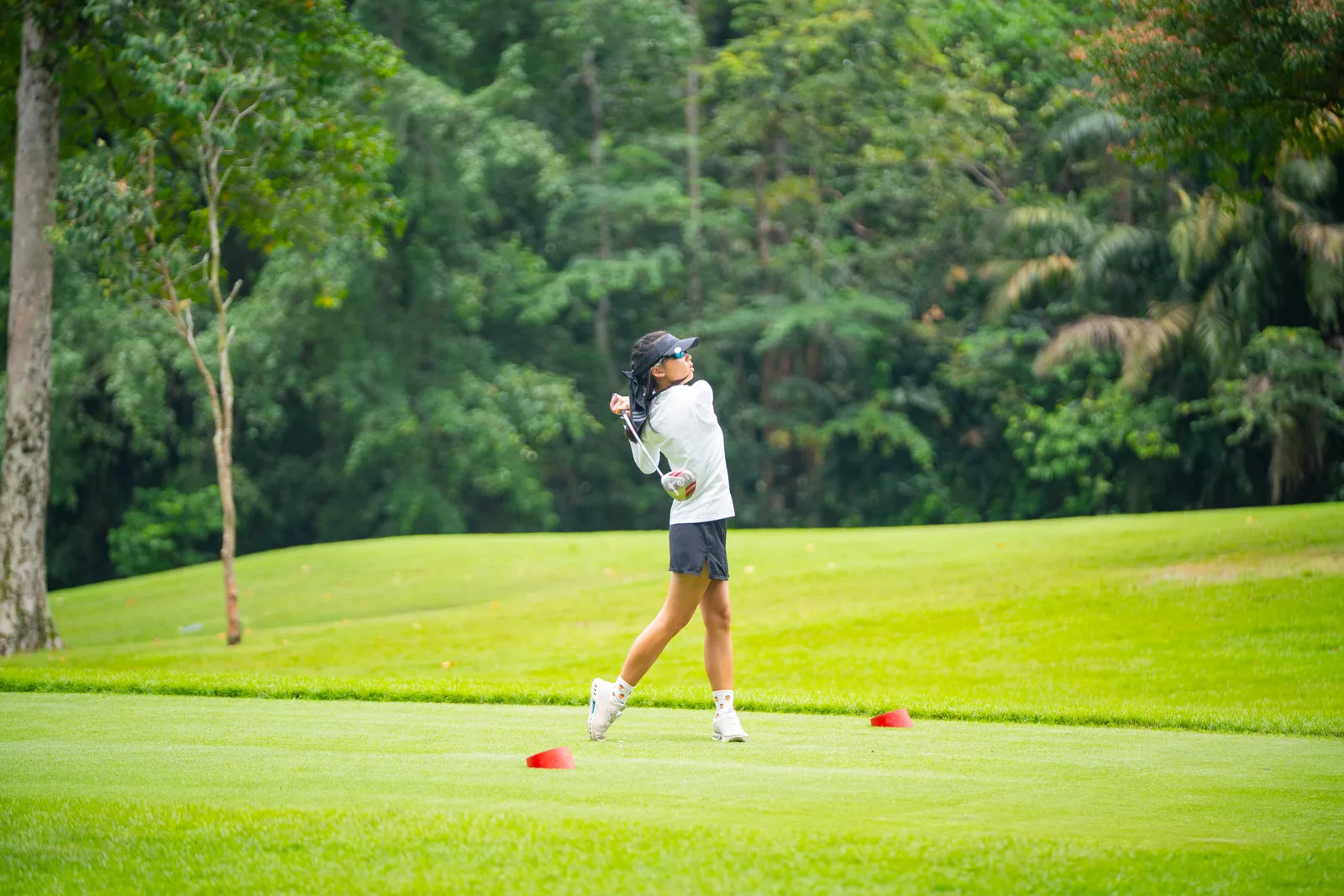 Golfer mid-swing with clean green negative space — tidy and corporate-golf-day relevant, but a fairly safe, distant frame with modest wow