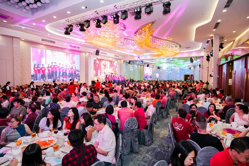 Chandelier ballroom with a full house of banquet tables during a company dinner and dance