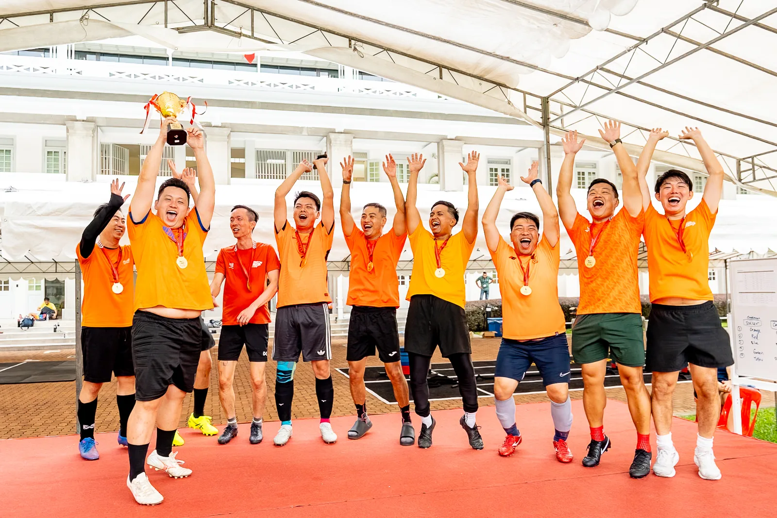 Trophy-cheer team moment, arms up, real joy, decent timing