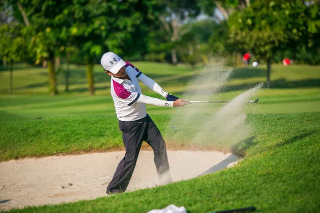 Golfer playing from a bunker at a corporate golf tournament