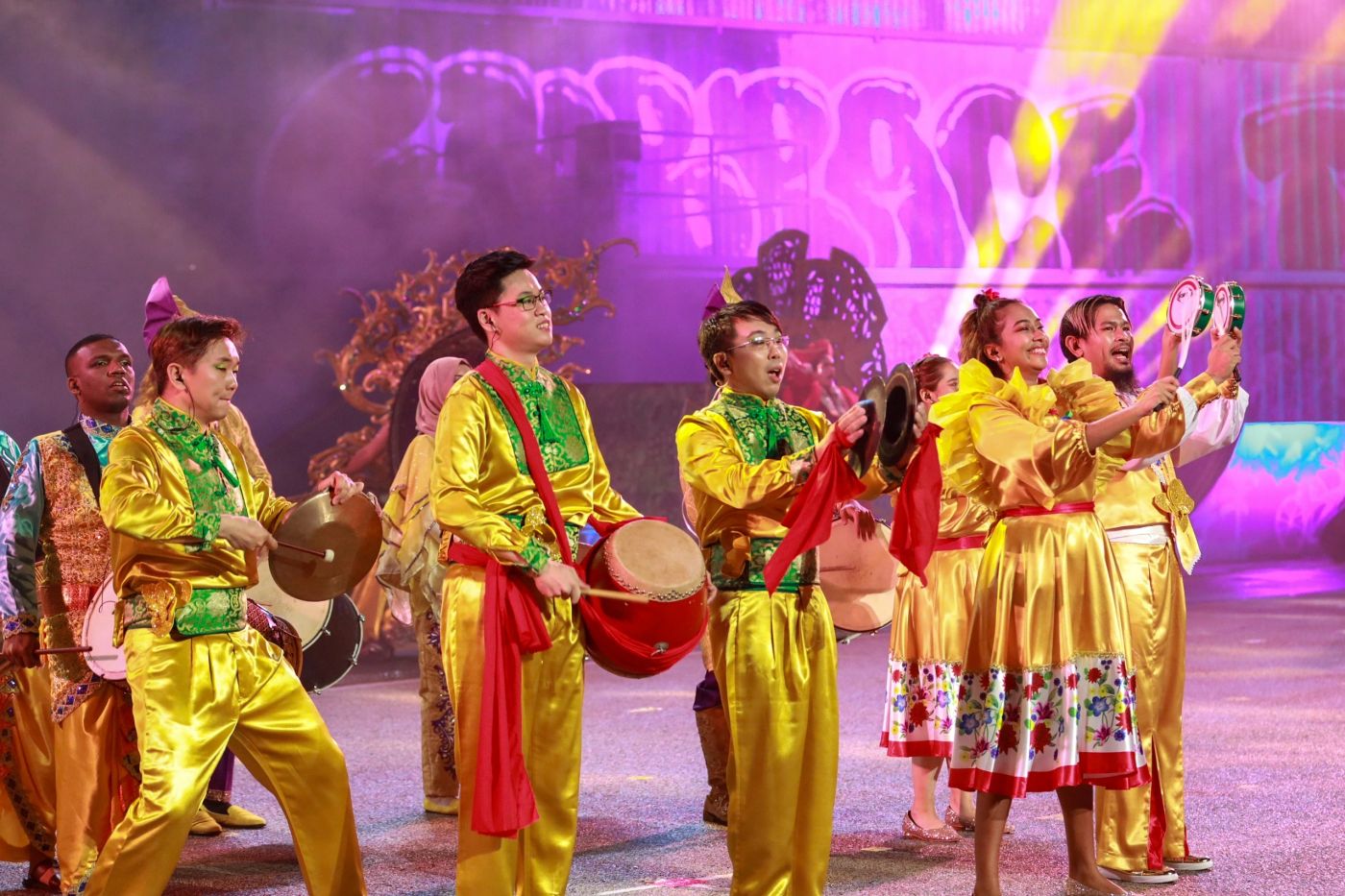 Drummers in gold costumes performing at a cultural celebration