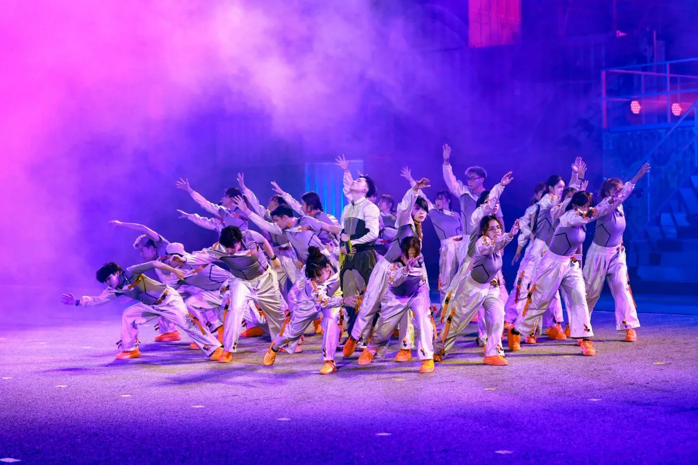 Dance crew mid-routine on a purple-lit stage