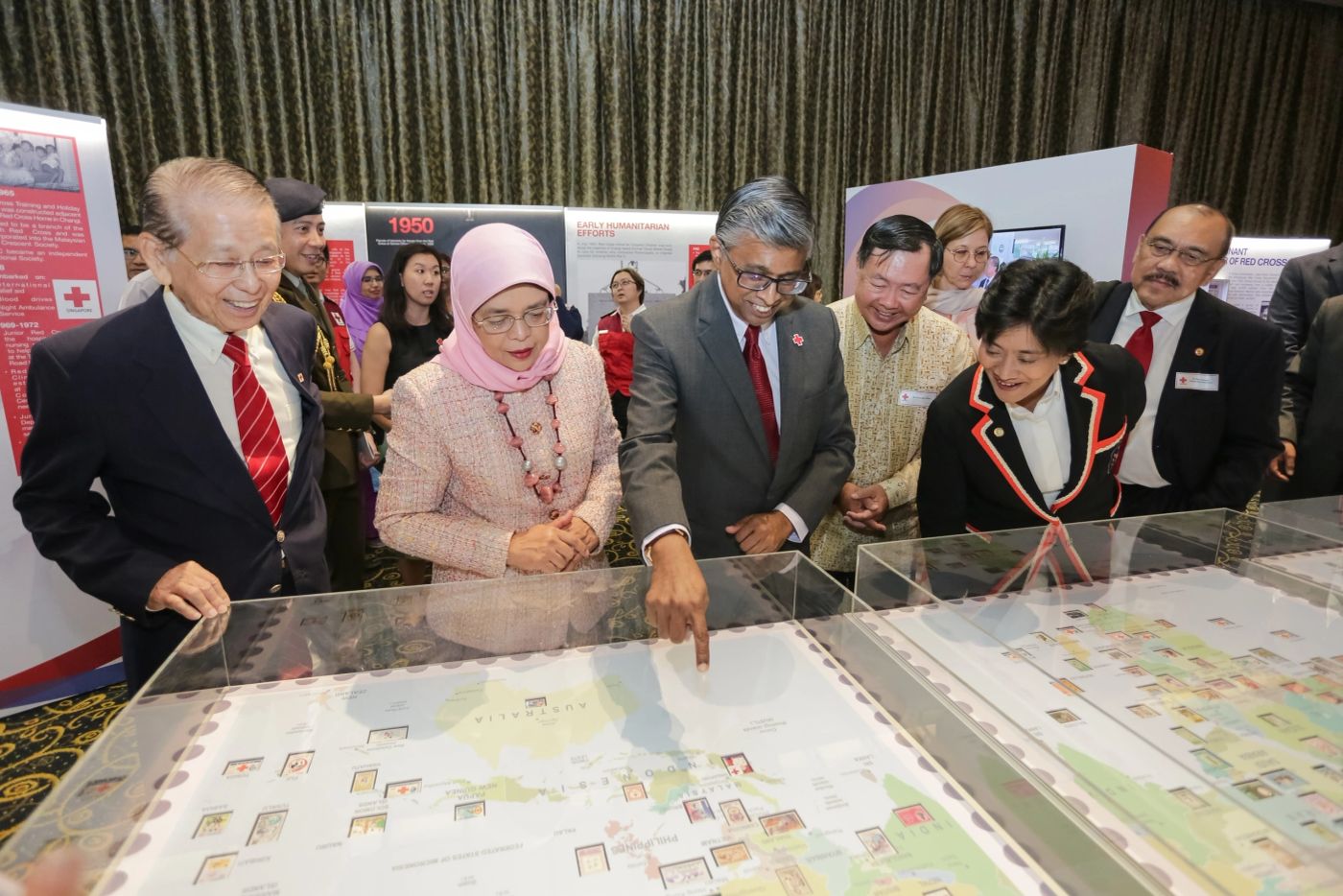 VIP guests studying an exhibit table at a heritage showcase