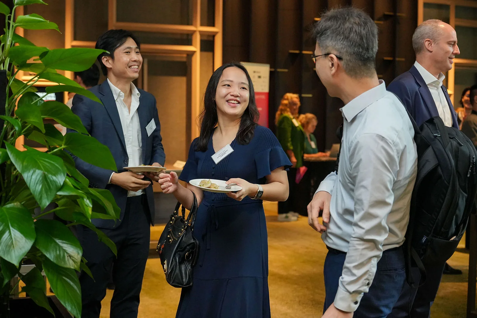 Conference guests in a hotel atrium space with planting and natural light — RS Photography