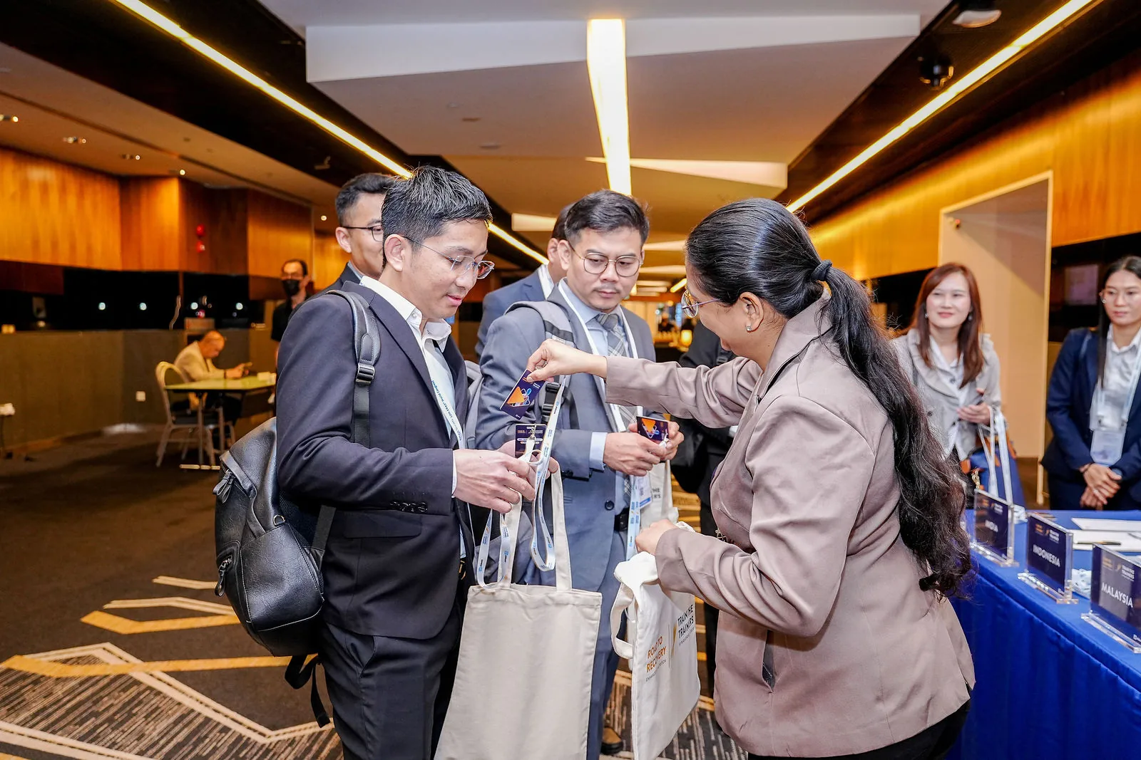 Delegates collecting materials in a Suntec Singapore foyer between sessions — RS Photography